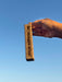 Hand holding a cork with text against a clear blue sky