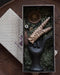Decorative item with leopard print design in a box on a textured surface