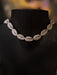 Necklace made of cowrie shells on a black mannequin with a blurred background