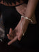 Close-up of a person's hand with a bracelet on a dark background