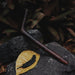 Dark-colored hairpin on a leaf with a blurred natural background