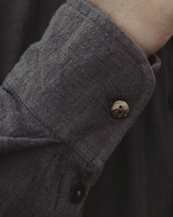 Man in a relaxed-fit brown cotton shirt with a mandarin collar, showcasing boho tribal fashion by the poolside