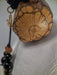 Wooden pendant with intricate carvings on a plain background