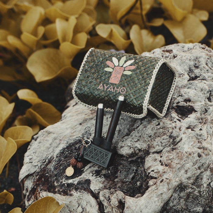 Small bag with a flower design and 'AYAHO' text on a textured rock surface with yellow leaves in the background