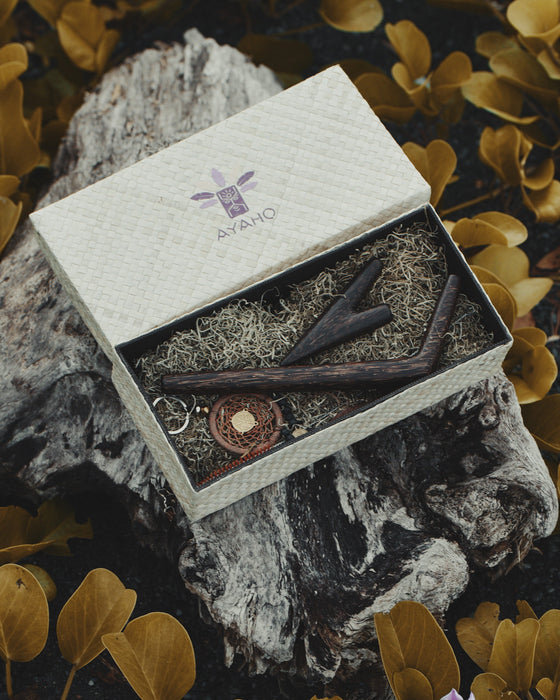 Gift set with tools and accessories in a branded box on a textured surface with leaves.