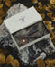 Gift set with tools and accessories in a branded box on a textured surface with leaves.