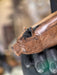 Wooden handle with a carved bear head design, held by a person's hand.