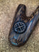 Wooden object with a decorative emblem on a textured surface