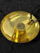Gold pendant with a black cord on a dark background