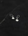 Silver earrings on a textured black surface