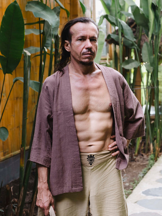 Man in traditional attire standing in a garden setting
