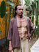 Man in traditional attire standing in a garden setting