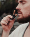 Man holding a black and orange Ayahobrush against his face