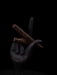 Dark hand holding two sticks against a black background