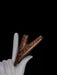 Wooden object on a white hand against a black background