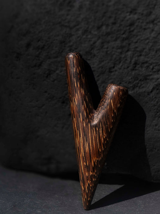 Wooden archery bow nock on a dark background