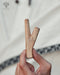 Hand holding two wooden sticks with a blurred background