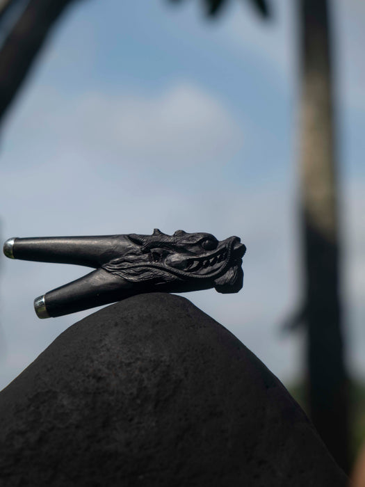 Black decorative object on a rock with a blurred natural background