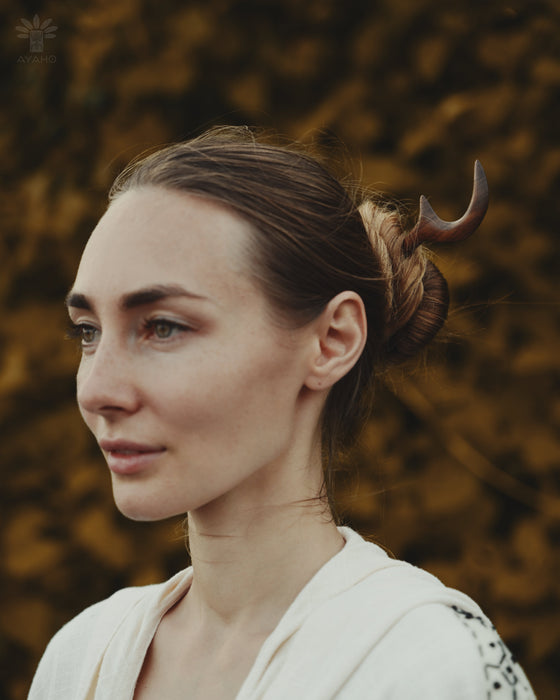 Simple crescent moon design in smooth teak, pinned into a low bun for understated charm