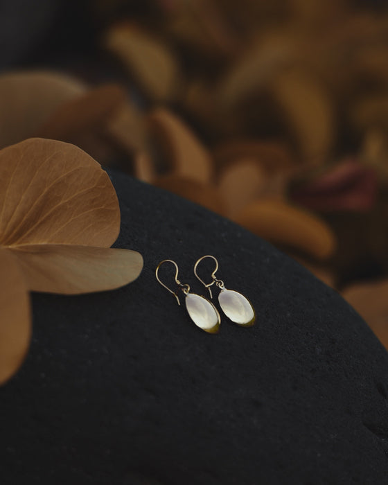 Compact bronze mirror studs in a suede pouch, ideal for on-the-go spiritual protection.