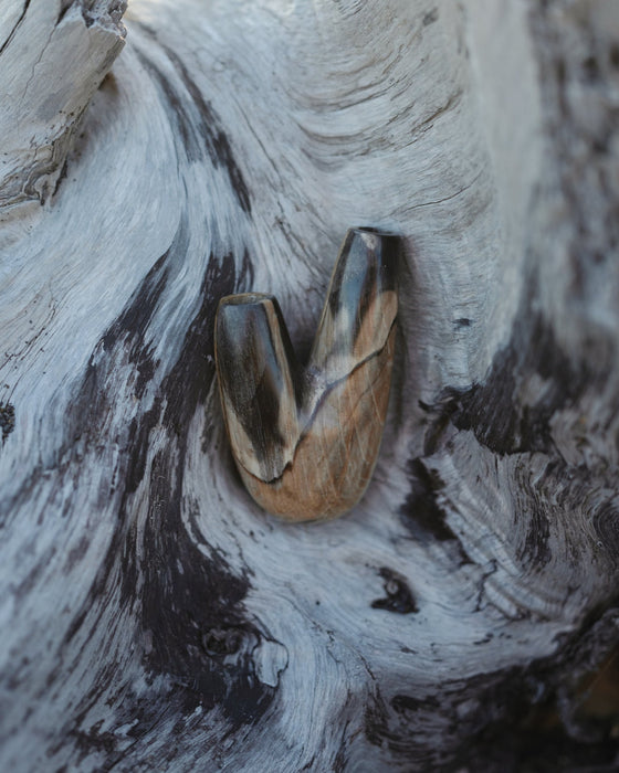 Earthy aesthetic of the Kuripe pipe crafted from petrified wood, blending with nature.