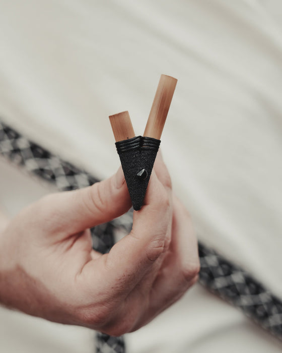 Artisan-crafted nasal pipe made from fire-treated bamboo, adorned with natural stones for spiritual medicine administration