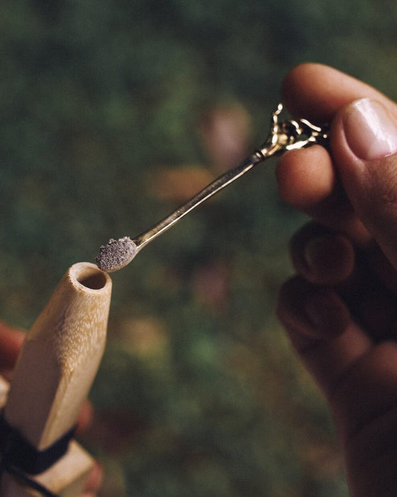 Held aloft, a premium metal Spiritual Powder Spoon intricately crafted for precise use in shamanic rituals and as a decorative element for kuripe pipes