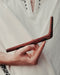 Hand holding a wooden tool against a white background
