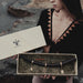 A person holding a box containing a shamanic Tepi, which is a smoking accessory made of mango wood and rosewood with silver and bronze tips, and embellishments.