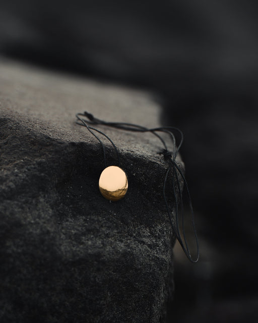 Small copper mirror pendant on an adjustable cord, tucked into a suede pouch for on-the-go spiritual practice.