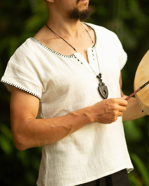Crafted with meticulous attention to detail and a deep respect for ancient traditions, this boho-style short sleeve shirt is more than just clothing; it's a statement of identity and power