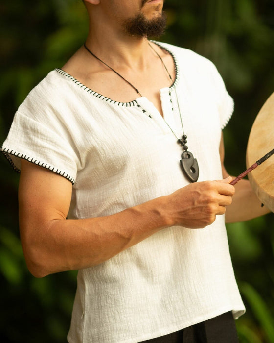 Crafted with meticulous attention to detail and a deep respect for ancient traditions, this boho-style short sleeve shirt is more than just clothing; it's a statement of identity and power