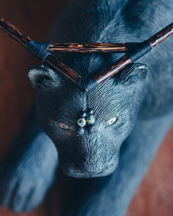 Wooden deer head with antlers and decorative beads on a dark background