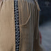 Close-up of a beige garment with a black and white patterned trim, featuring the AYANO brand logo.