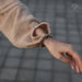 Close-up of a person wearing a beige textured sleeve with a blurred background