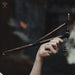 Hand holding a pair of wooden drumsticks with a blurred background