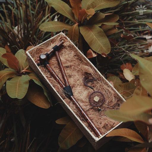 Set of wooden tools in a natural box with plants in the background
