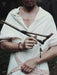 Person holding a wooden staff with a dark background
