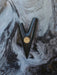Black and gold decorative item on a textured surface