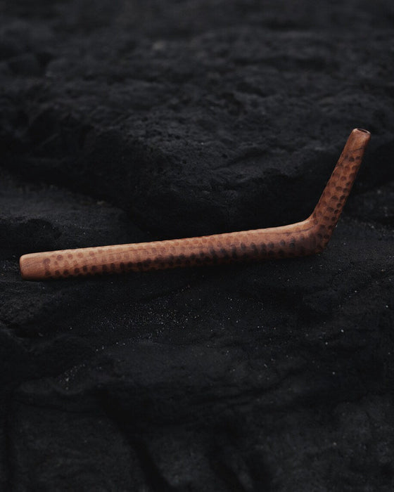 Brown cylindrical object on a textured black surface