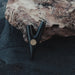 Black metal clip with gold emblem on a textured surface