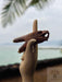 Wooden handcrafted tool held by a hand with a blurred natural background