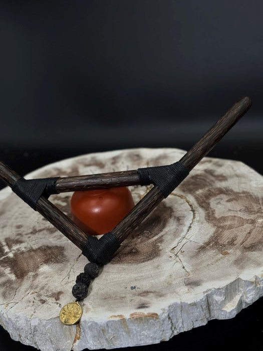 Small wooden bow and arrow with a red stone on a textured surface