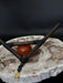 Small wooden bow and arrow with a red stone on a textured surface