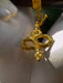 Gold snake-shaped pendant on a white surface