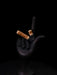 Black hand holding two cigarettes with smoke on a black background