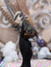 Black hand holding a piece of wood against a blurred background with crystals and patterns