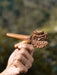 Wooden dragon handle held by a hand with a blurred natural background