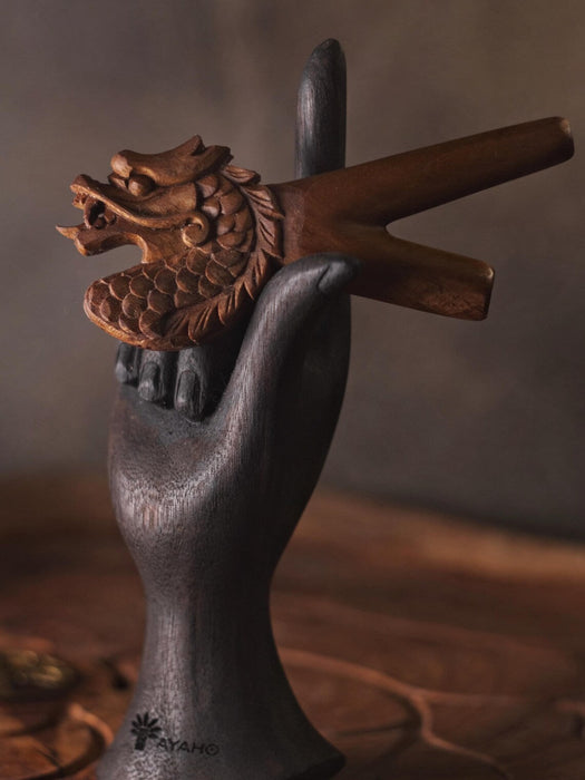 Decorative item with a dragon head and crossed swords on a dark background