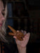 Person holding a wooden dragon figurine against a dark background